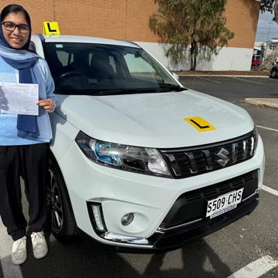 A student celebrating a first attempt pass, holding her Certificate of Competency