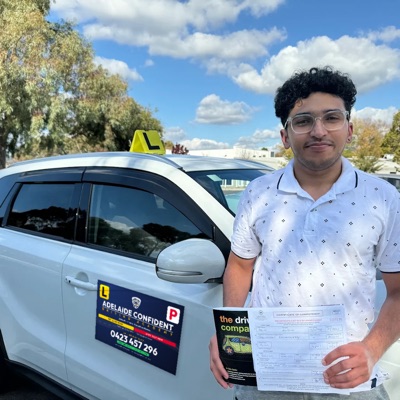 A student celebrating a first attempt pass, holding his Certificate of Competency